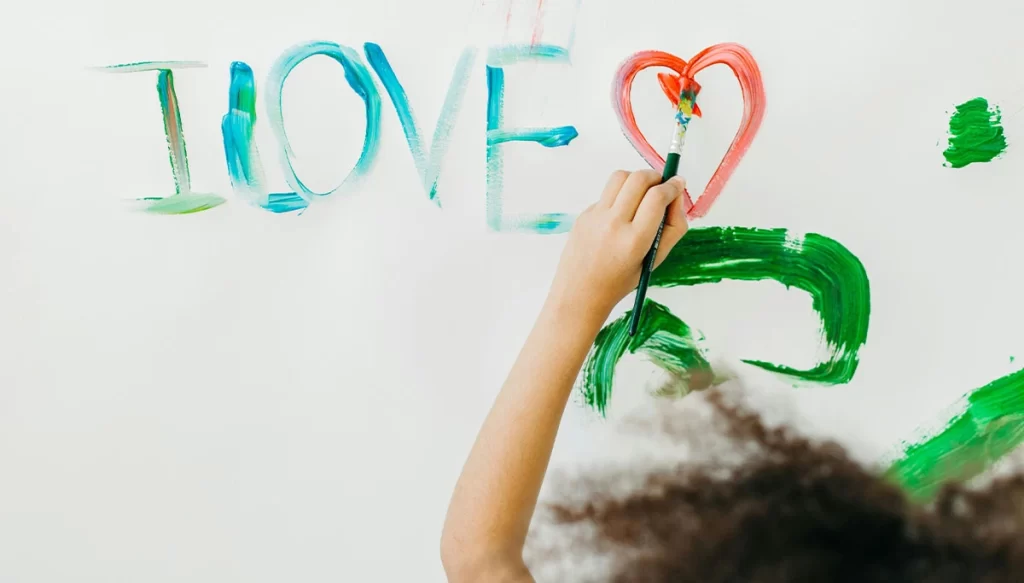 child writing love on a surface