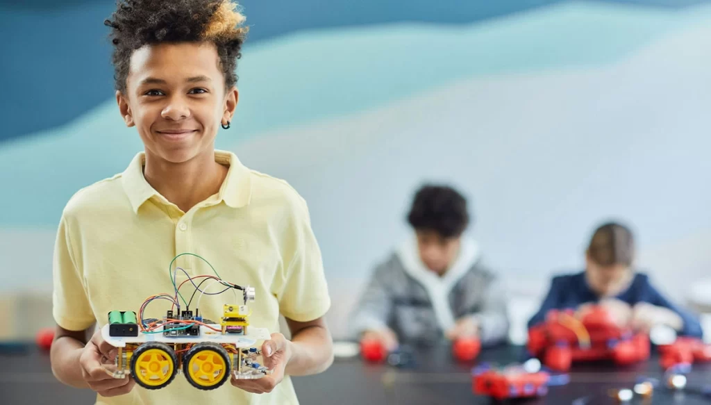 Young Boy holding a self made mechanical vehicle
