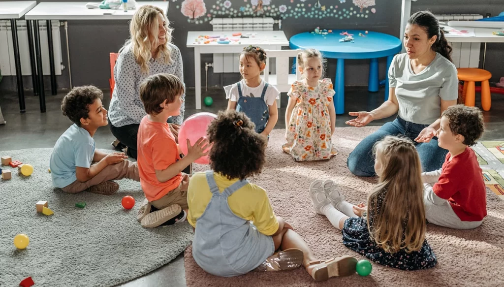 children and adults sitting in a circle while in a classroom