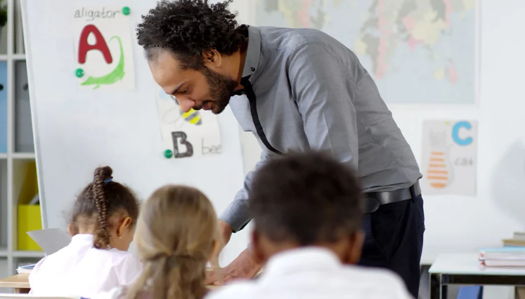 teacher assisting other kids in class