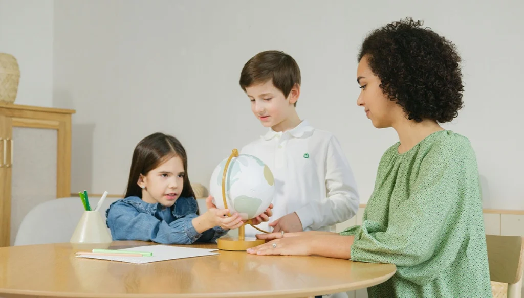 female teacher assits boy and gril with classwork