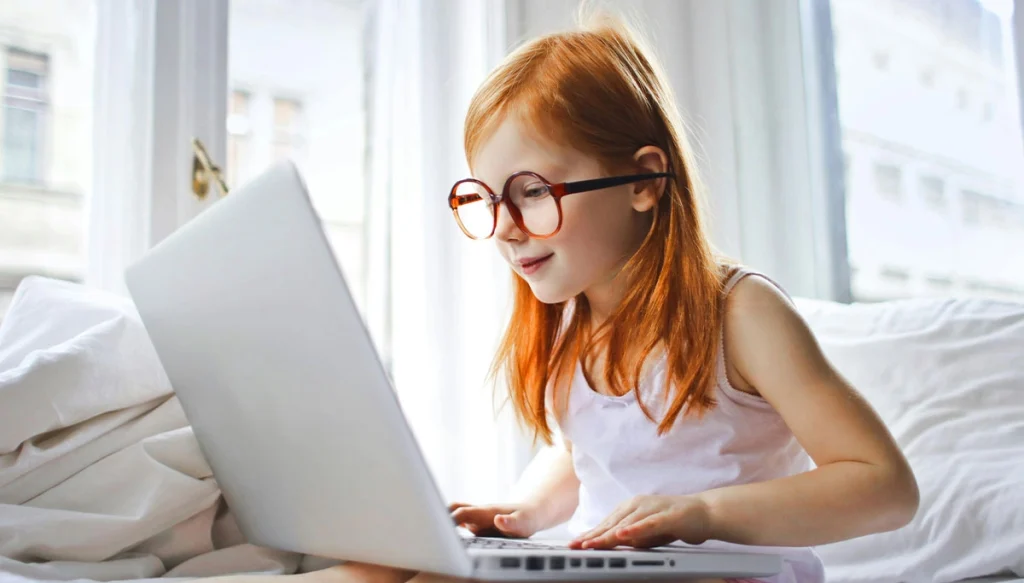 Young girl sitting infront of Laptop